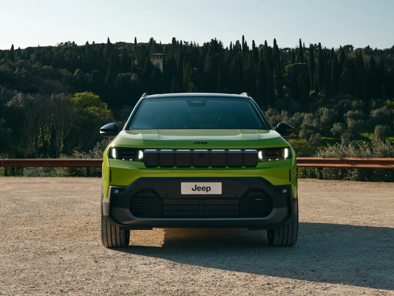 "Jeep Compass EV parked on a city street, showcasing sleek electric SUV design, modern LED headlights, and aerodynamic body lines."